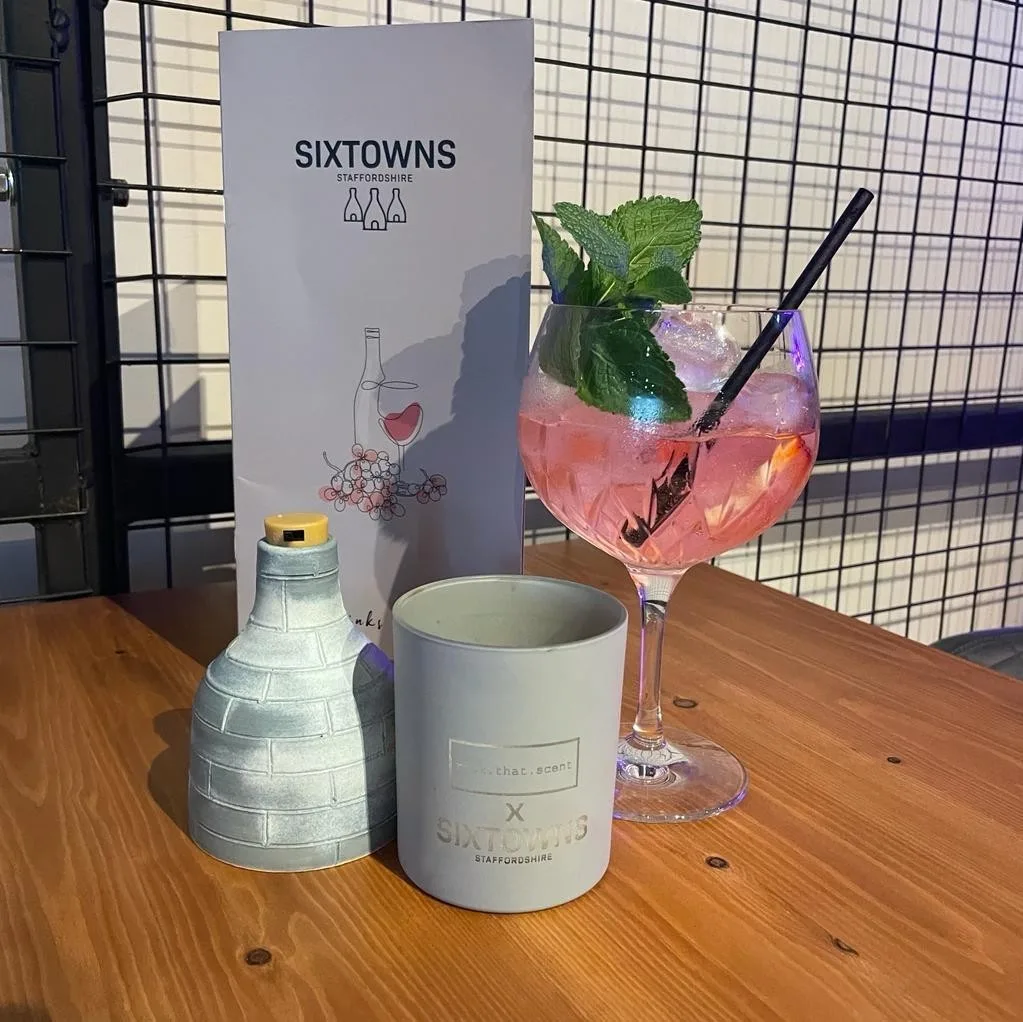 A Sixtowns cocktail with bottle and candle